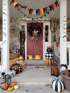 a front porch decorated for halloween with pumpkins and decorations