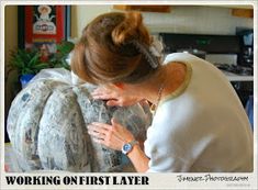 a woman is working on a sculpture in her living room with the caption'working on first layer '