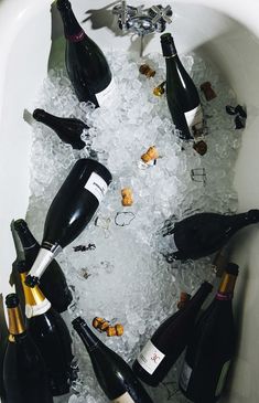 several bottles of wine are in an ice bucket