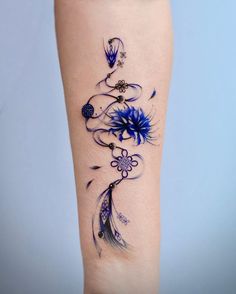 a woman's leg with blue flowers and feathers on her left side, tattoo style