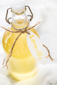 a bottle filled with liquid sitting on top of a white cloth covered table next to a tag