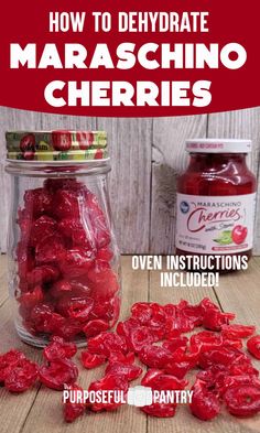 jars filled with red cherries sitting on top of a wooden table