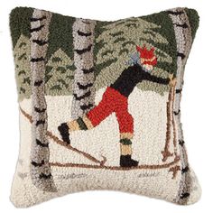 an embroidered pillow with a skier in the woods