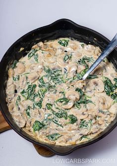 a skillet filled with mushrooms and spinach