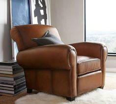 a brown leather chair sitting in front of a window