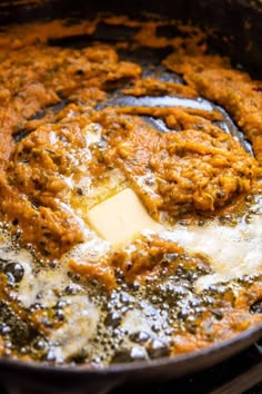 an iron skillet with some food cooking in it and cheese being melted on top