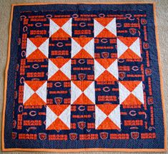 an orange and blue quilt on the floor