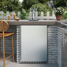 an outdoor kitchen with bar stools next to it