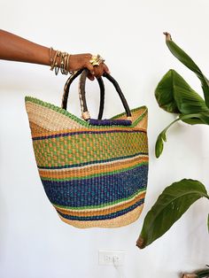 A beautiful authentic one-of-a-kind handwoven market basket tote handmade in Bogatanga. Each bag is beautifully woven by hand with thick, natural and dyed elephants grass to create a beautiful pattern and leather wrapped handles. This is the perfect market bag for trips to the farmers market, the beach, picnics or storage. Size: 13”H x 17”W x 10”D *One-of-a-kind, 1 of 1. Crochet Hobo Bag, Cowrie Shell Jewelry, Beach Picnics, African Dolls, African Market, Market Basket, Basket Tote, Market Baskets, Market Tote