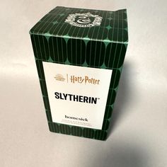 a harry potter slytherin box on a white surface with the lid open and it's contents visible