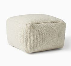 a white square ottoman sitting on top of a floor