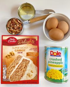 ingredients to make cake sitting on top of a white table next to an empty can