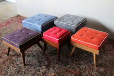 four colorful stools sitting on top of a rug