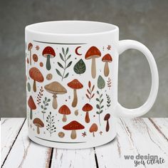 a coffee mug with mushrooms and leaves painted on the inside is sitting on a wooden table