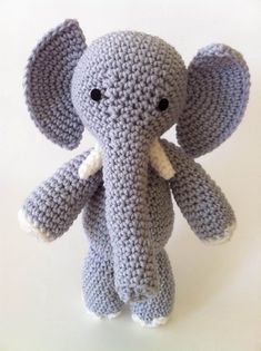 a crocheted stuffed elephant sitting on top of a table