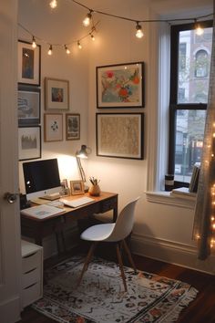 a home office with lights strung from the ceiling and pictures on the wall above it