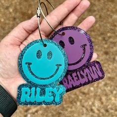 two handmade tags with smiley faces and the words rules on them are held in front of a person's hand