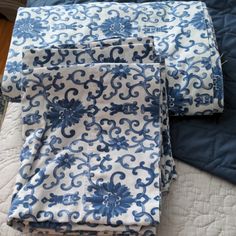 two blue and white bedspreads on top of a bed next to each other