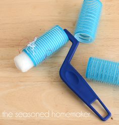 a pair of scissors and some yarn on a wooden table with a thread spool