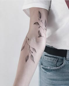 a woman's arm with leaves on it