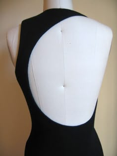 a mannequin wearing a black and white bodysuit with an open neckline