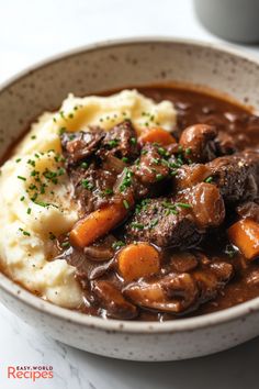 a bowl filled with stew and mashed potatoes on top of a white countertop