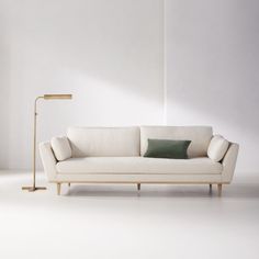 a white couch sitting next to a floor lamp