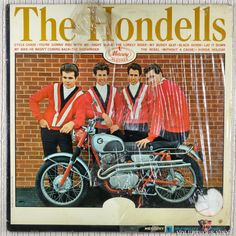 an old magazine cover with three men standing next to a motorcycle