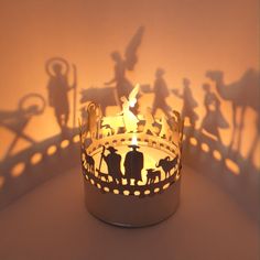 a candle that is sitting in the shape of a crown with people and animals on it