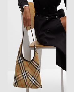 "Find BURBERRY Small Check Twill Shoulder Bag on Editorialist. This Burberry shoulder bag is crafted from check twill cotton and smooth calf leather. The bag features an open top, a shoulder strap, and a detachable zip pouch bag. The interior is lined with cotton. The bag measures approximately 10.4\"H x 18.3\"W x 5.3\"D. Made in Italy."