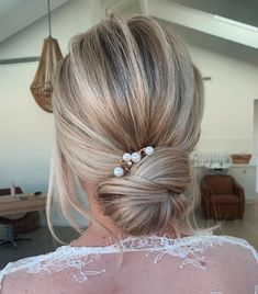 a woman with blonde hair and pearls in her hair is seen from the back view