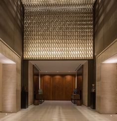 an empty lobby with wooden doors and lights