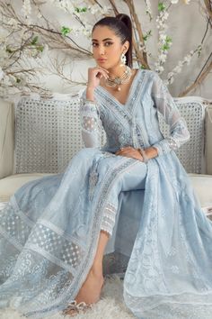 On a canvas of refreshing sky-blue hue, this silk net effortless, flowing angrakha kalidar is adorned with delicate shimmering swarovski crystals, pearls, sequins, mirror & silk thread work in dreamy pastel hues. Glamorously composed sleeves, hand-crafted glistening tassels, embroidered border & scalloped laces complete its look. This stunning floor-length kalidar is off set with a ruffle detailed draped dupatta and lace detailed stylish pant adding distinct elegant flair to entire look. Shirt F Luxury Light Blue Chanderi Traditional Wear, Luxury Light Blue Embroidered Traditional Wear, Blue Silk Shirt, Pakistani Boutique, Sky Blue Dress, Pakistani Designer Clothes, Organza Sleeves, Stylish Pants, Organza Dupatta