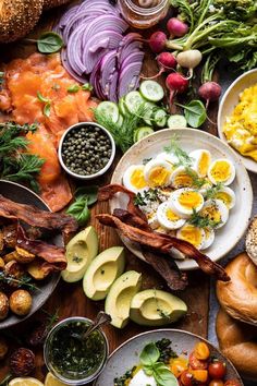 an assortment of food is laid out on a table with bread, vegetables and eggs