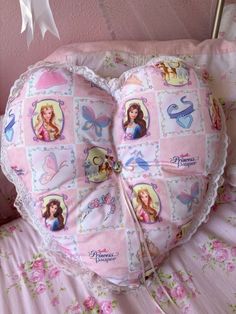 a pink pillow with pictures of princesses on it