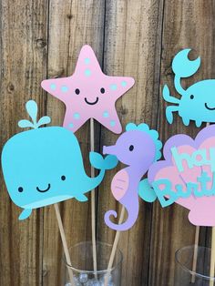 there are some cupcake toppers with sea animals on them and one is holding a starfish