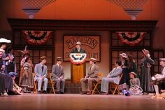 a group of people sitting on chairs in front of a stage