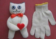 two knitted gloves with eyes, one wearing a bow tie and the other holding a heart