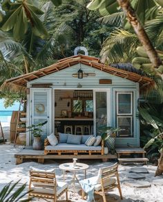 a small blue house sitting on top of a sandy beach