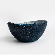 a black bowl with blue speckles on it