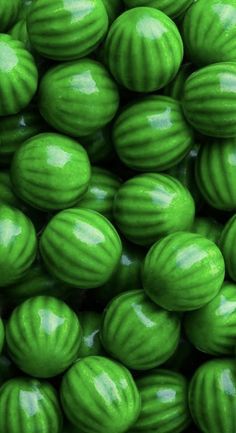 green candy balls are stacked on top of each other in this close up photo,