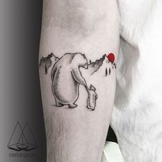 a man with a bear tattoo on his leg holding a red balloon in the air