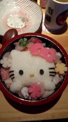 a hello kitty sushi bowl is shown with chopsticks and utensils