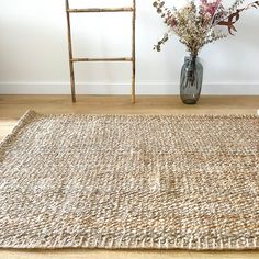 a vase filled with flowers sitting on top of a rug