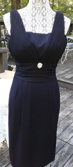 "This is the ultimate little black dress.  1950s/60s. Fully lined, pleated bust, shirred waist, pleats at front of skirt and pleat at hem in back to help when walking. Waist embellished with faux rhinestone brooch. MEASUREMENTS (LAYING FLAT) Bust - 18\" Waist - 15-1/2\" Hips - 20\" Shoulder to hem - 43\"" Formal Fitted Dresses With Accordion Pleats, Classic Pleated Dress For Cocktail, Classic Formal Pleated Dress With Box Pleat, Classic Formal Pleated Dress With Pleated Back, Elegant Fitted Pleated Dress With Box Pleat, Elegant Fitted Dress With Box Pleat, Classic Fitted Dress With Accordion Pleats, Classic Fitted Dress With Pleated Bodice, Classic Fitted Pleated Dress