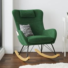 a green rocking chair with a pillow on top of it in front of a white wall