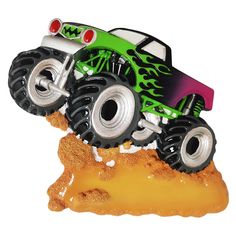 a green monster truck with flames on it's tires is driving through the sand