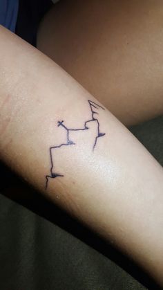 a person with a tattoo on their arm that has arrows in the shape of letters