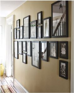 a wall with many framed pictures on it