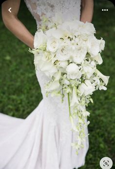 a bride holding a bouquet of white flowers